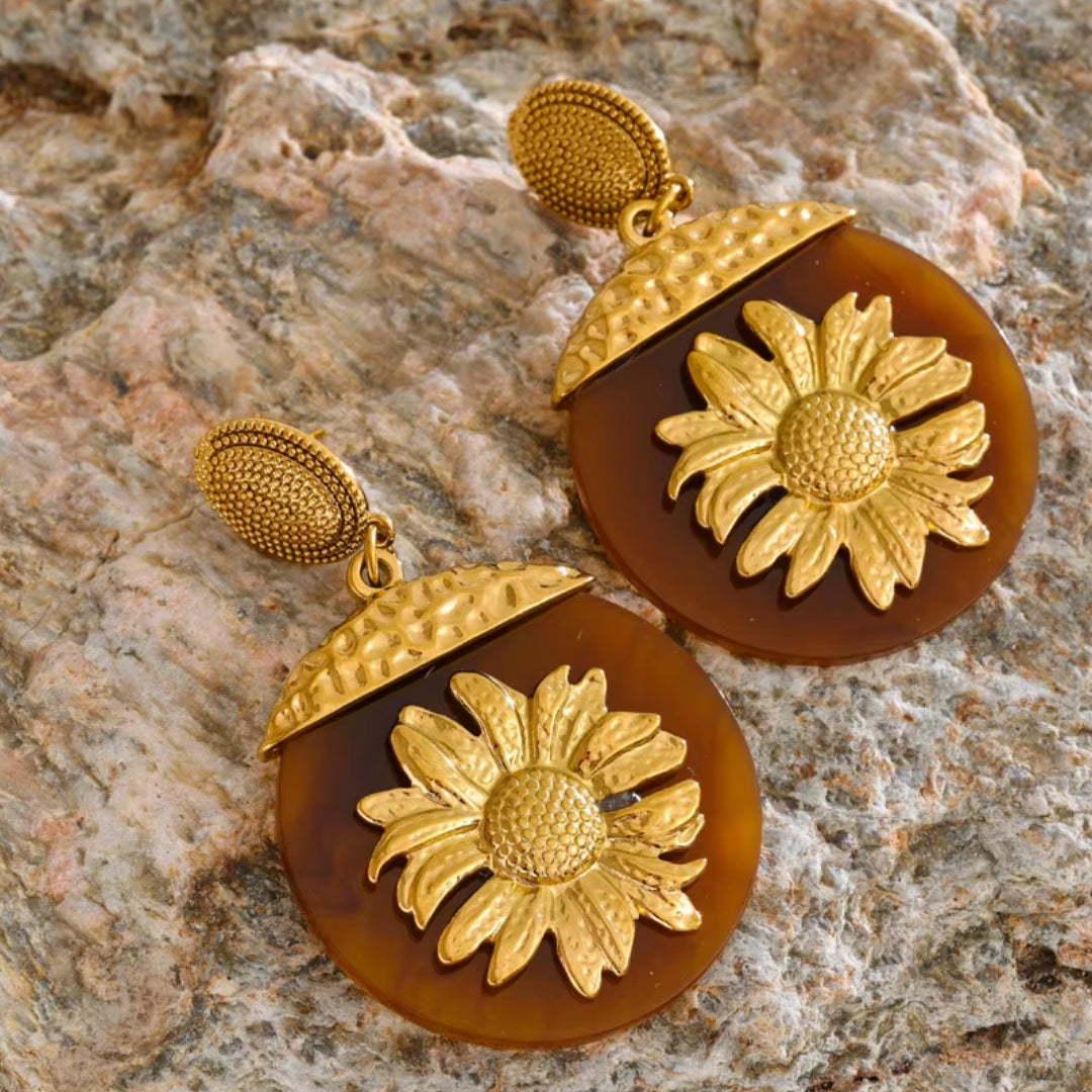 Aretes Girasol Lux en resina floral – lenorajewelry.com/aretes-girasol-lux, aretes florales, aretes de resina, aretes colgantes mujer, aretes dorados modernos, joyería con flores, aretes de lujo lenora, accesorios otoño invierno, aretes resistentes al agua, pendientes grandes, aretes llamativos