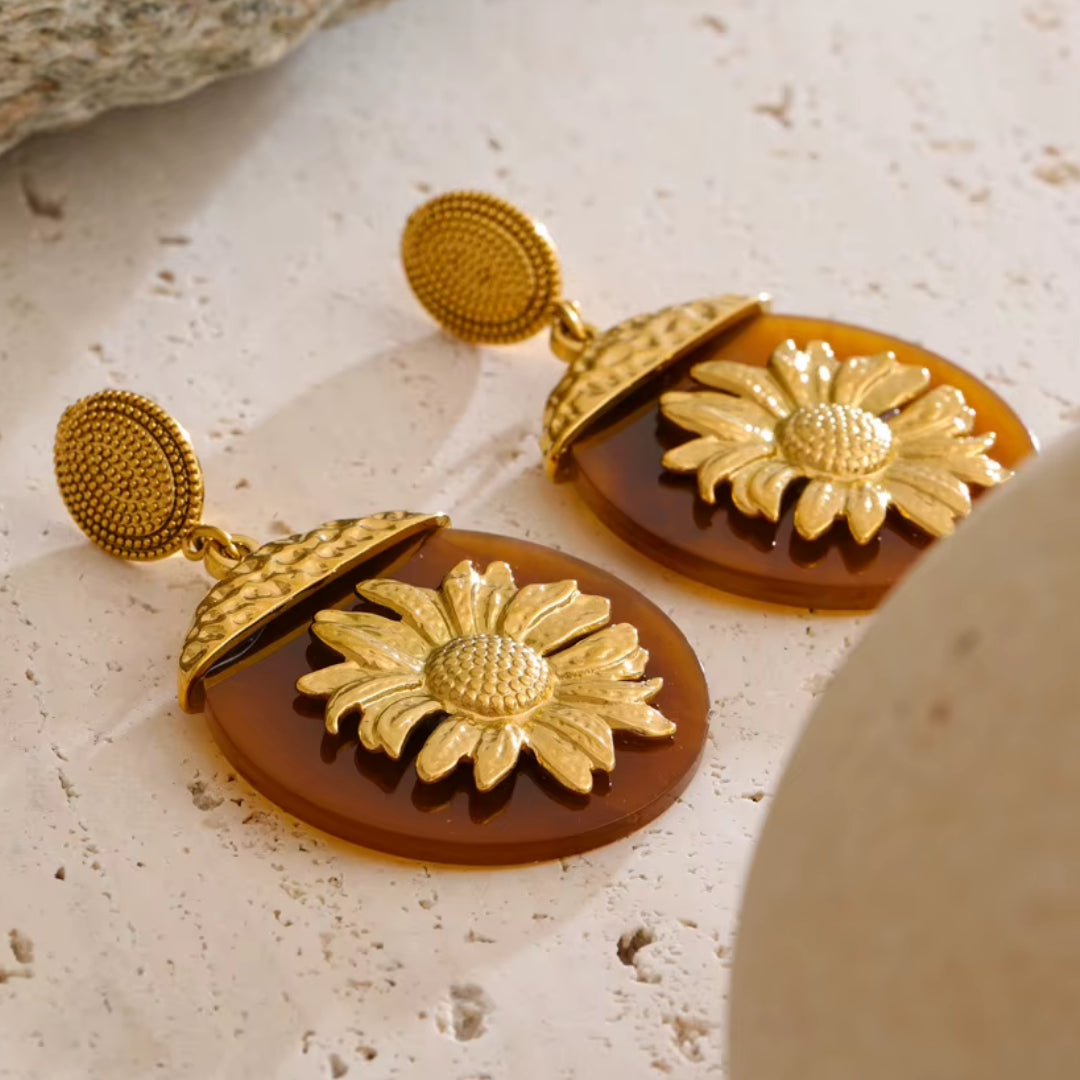 Aretes Girasol Lux en resina floral – lenorajewelry.com/aretes-girasol-lux, aretes florales, aretes de resina, aretes colgantes mujer, aretes dorados modernos, joyería con flores, aretes de lujo lenora, accesorios otoño invierno, aretes resistentes al agua, pendientes grandes, aretes llamativos