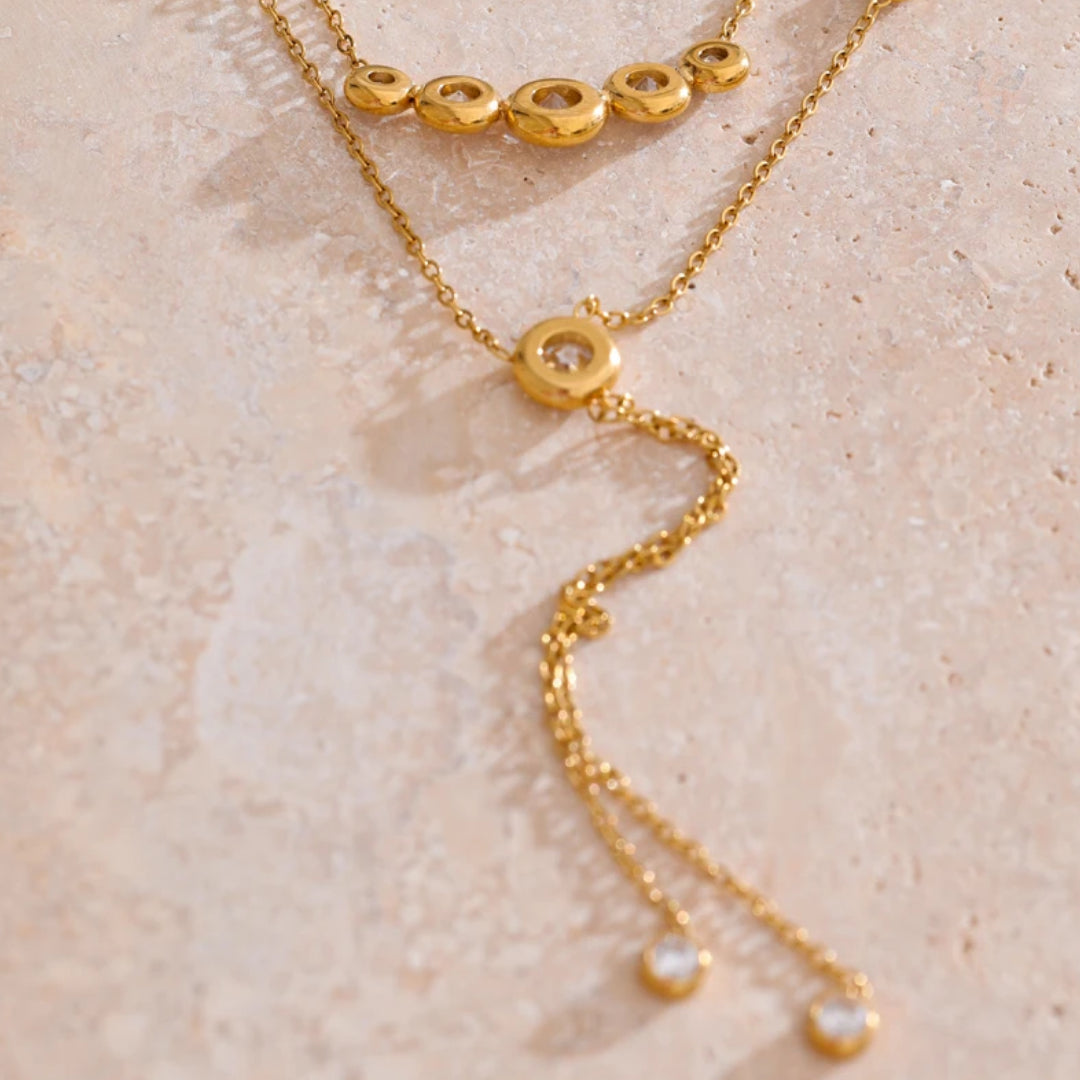 Collar dorado de doble cadena LENORA – lenorajewelry.com/collar-brisa-doble-cadena
collar con circonias cúbicas, collar doble cadena, joyería dorada para mujer, collar chapado en oro, collar resistente al agua, joyería fina LENORA, accesorios elegantes mujer