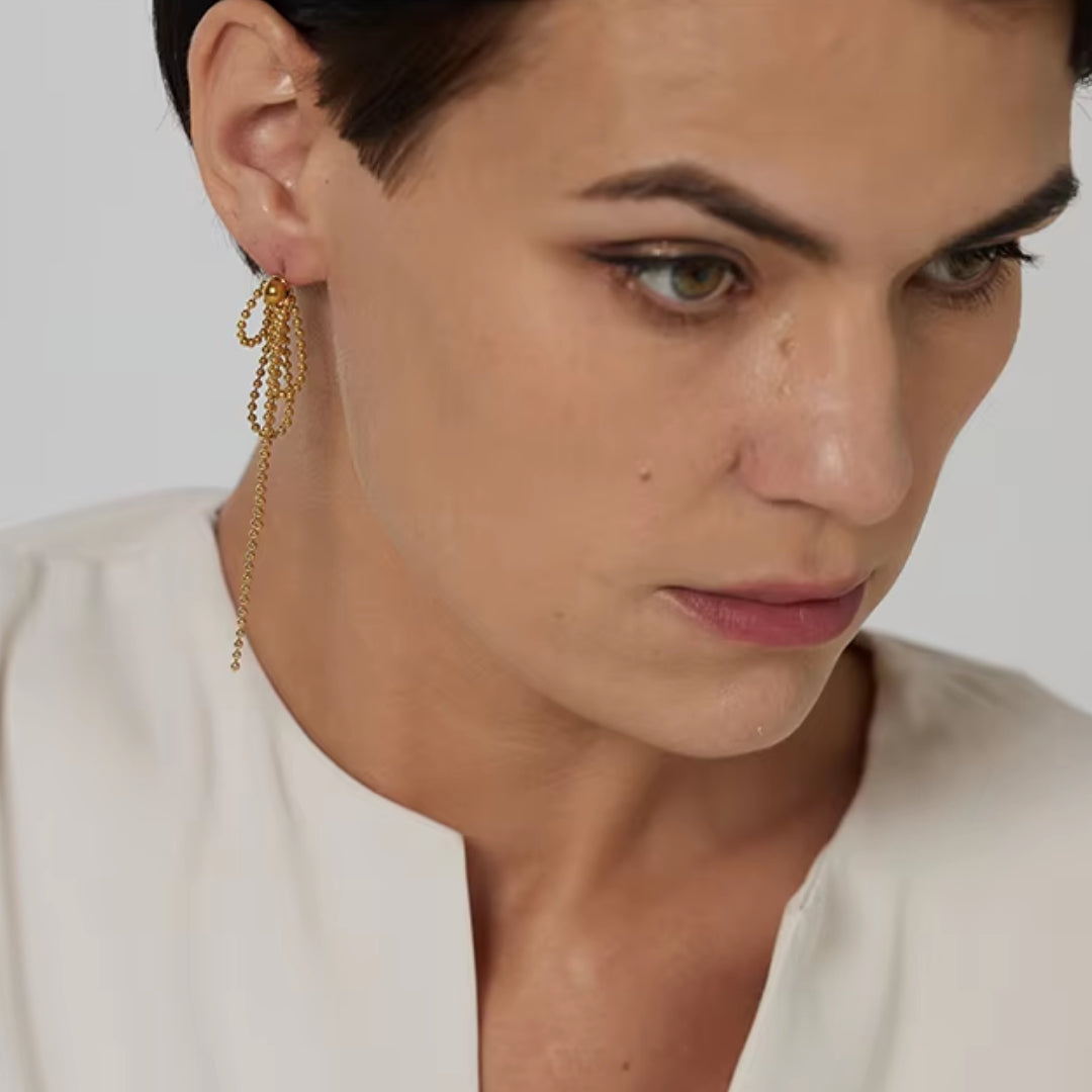 https://lenorajewelry.com/pendientes-esfera-doradapendientes colgantes geométricos, pendientes dorados ligeros, joyería de acero inoxidable, pendientes modernos para mujer, aretes largos elegantes, accesorios femeninos sofisticados, pendientes de cuentas doradas, joyería resistente y elegante