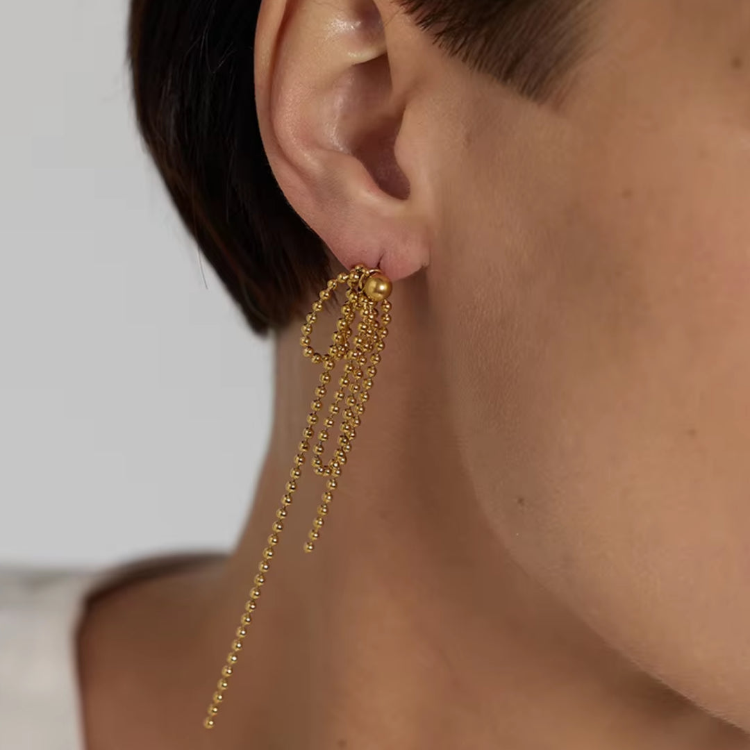 https://lenorajewelry.com/pendientes-esfera-doradapendientes colgantes geométricos, pendientes dorados ligeros, joyería de acero inoxidable, pendientes modernos para mujer, aretes largos elegantes, accesorios femeninos sofisticados, pendientes de cuentas doradas, joyería resistente y elegante