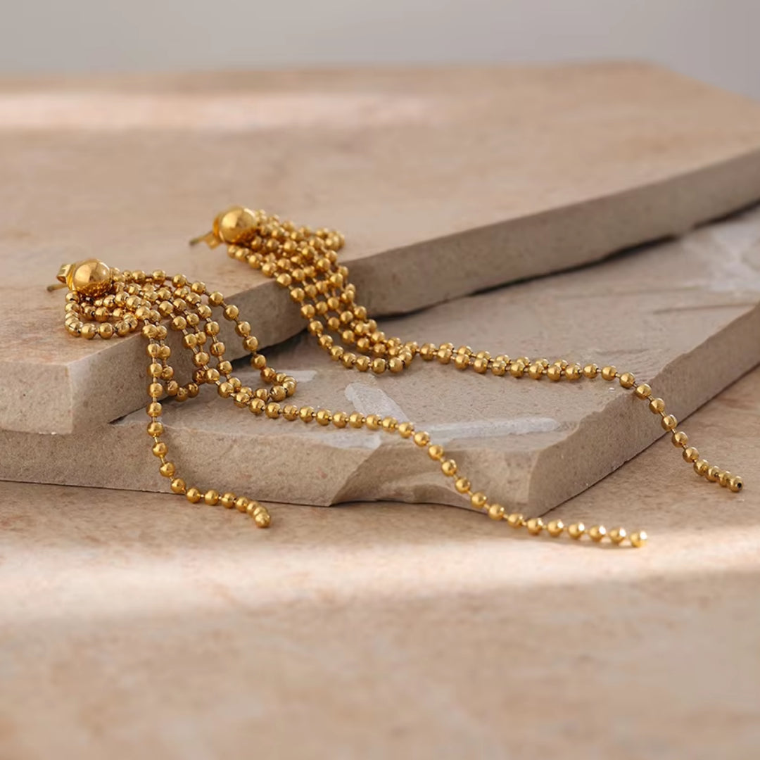 https://lenorajewelry.com/pendientes-esfera-doradapendientes colgantes geométricos, pendientes dorados ligeros, joyería de acero inoxidable, pendientes modernos para mujer, aretes largos elegantes, accesorios femeninos sofisticados, pendientes de cuentas doradas, joyería resistente y elegante