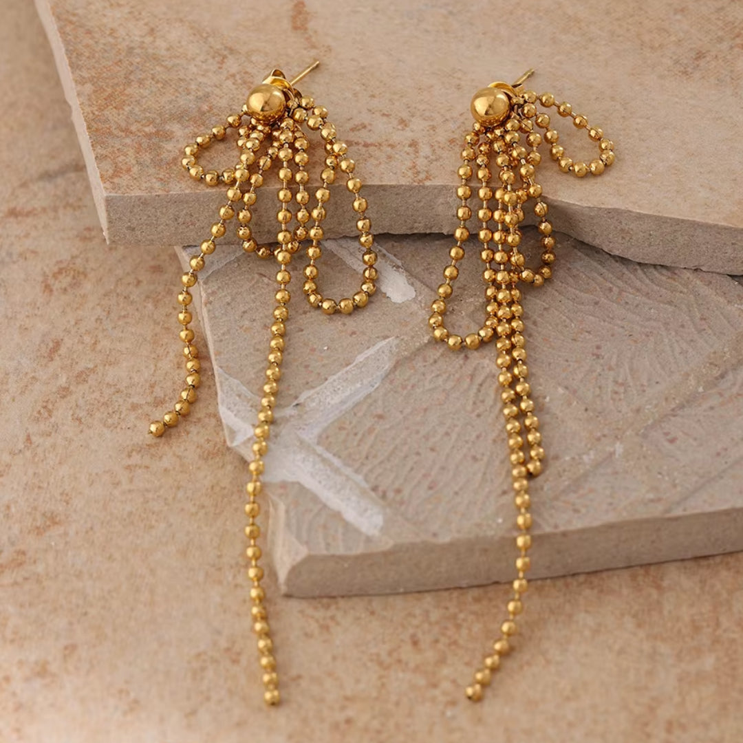 https://lenorajewelry.com/pendientes-esfera-doradapendientes colgantes geométricos, pendientes dorados ligeros, joyería de acero inoxidable, pendientes modernos para mujer, aretes largos elegantes, accesorios femeninos sofisticados, pendientes de cuentas doradas, joyería resistente y elegante