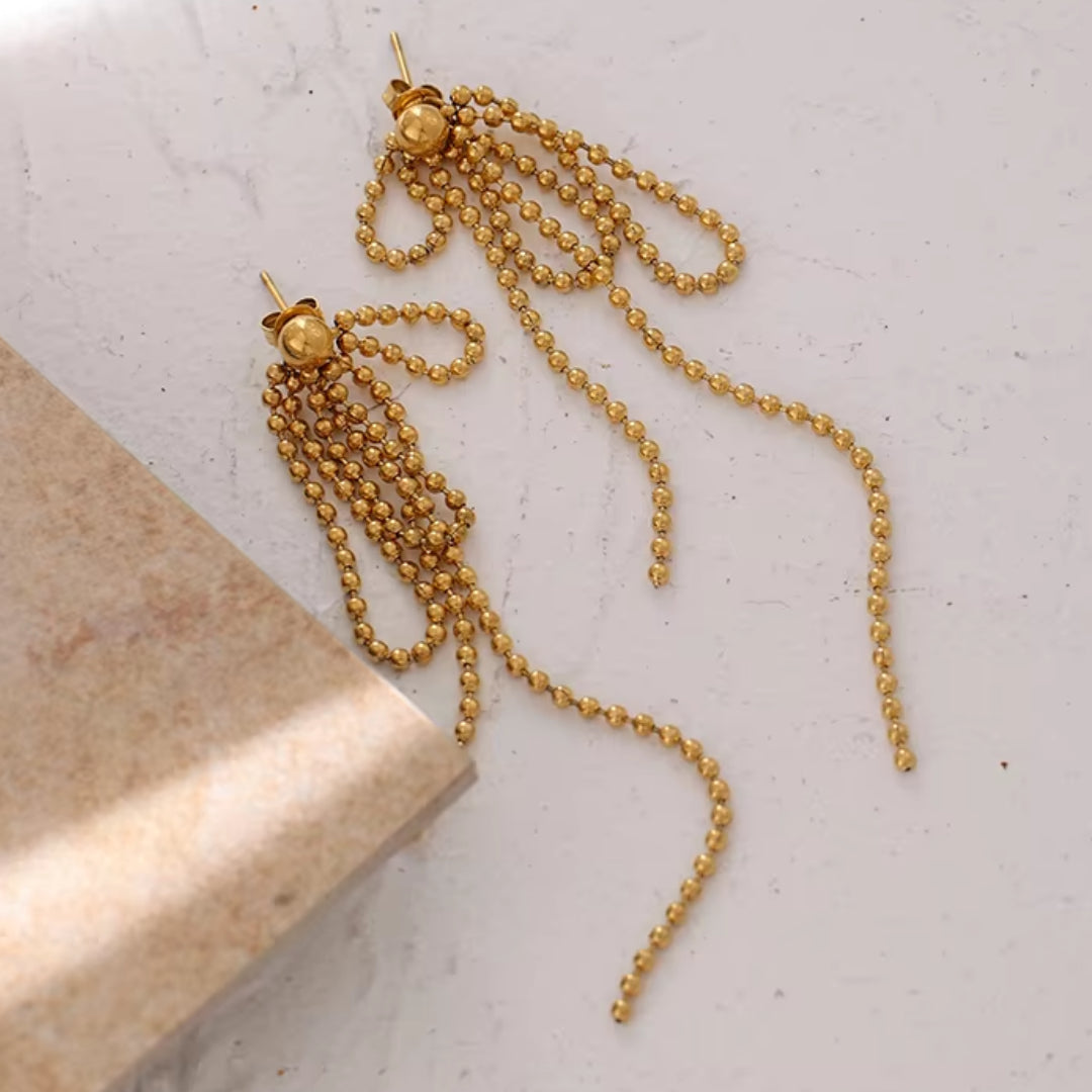 https://lenorajewelry.com/pendientes-esfera-doradapendientes colgantes geométricos, pendientes dorados ligeros, joyería de acero inoxidable, pendientes modernos para mujer, aretes largos elegantes, accesorios femeninos sofisticados, pendientes de cuentas doradas, joyería resistente y elegante